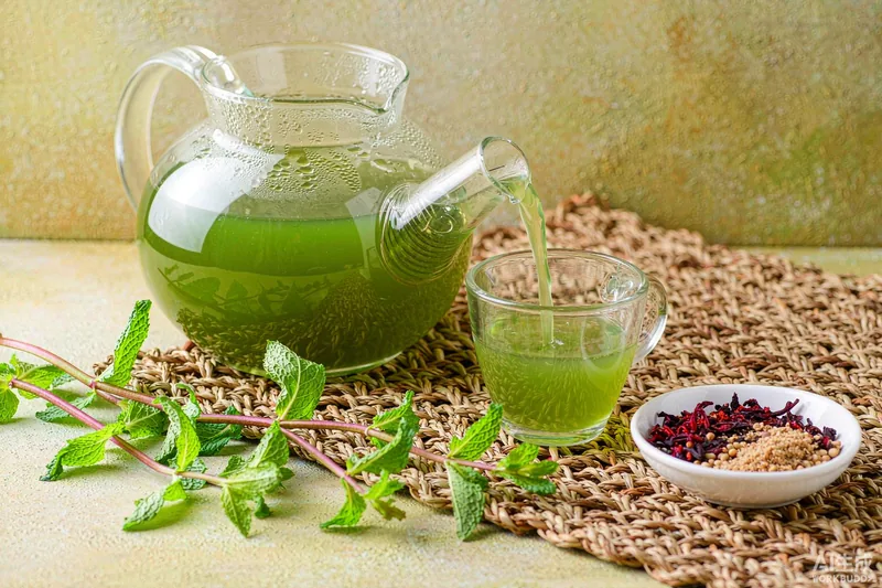 Bule de vidro servindo chá verde com hortelã e hibisco — chá para emagrecer funciona?