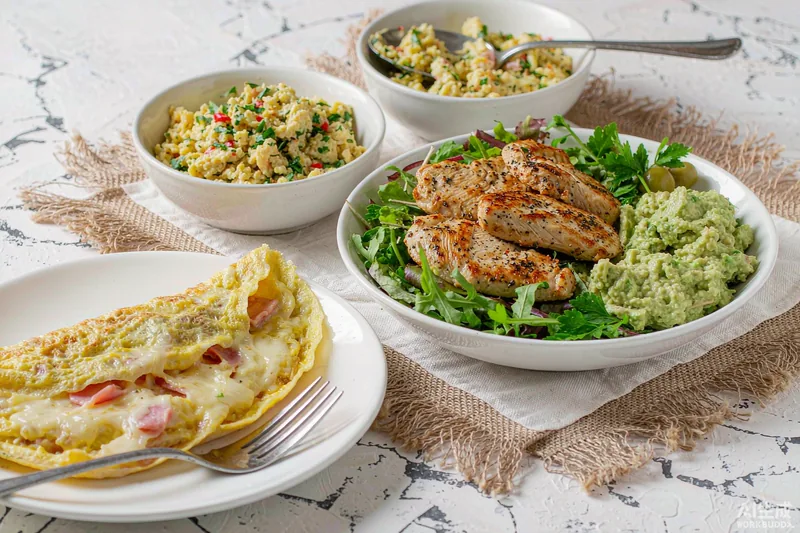 Mesa brasileira com ovos mexidos, frango grelhado e salada de abacate — receitas low carb